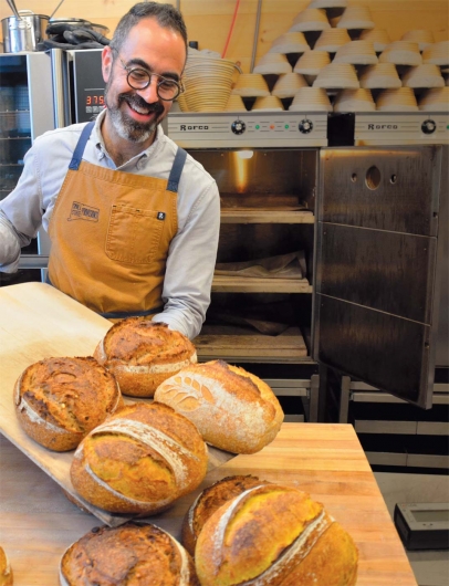 Baker Kevin Masse beams as he takes a fresh batch of his popular sourdough batards out of the oven.